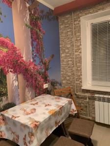 a table and chairs in a room with flowers at 139А Проспект Добровольского Уютная Трех Комнатная квартира в Одессе in Odesa +27 photos