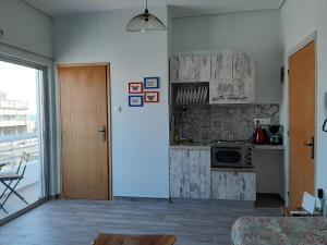 sala de estar con cocina con mesa y puerta en Central Mark Loft, en Volos