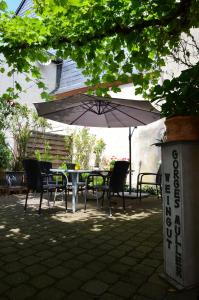 einen Tisch und Stühle unter einem Sonnenschirm auf einer Terrasse in der Unterkunft Altes Winzerhaus - Ferienhaus in Burgen