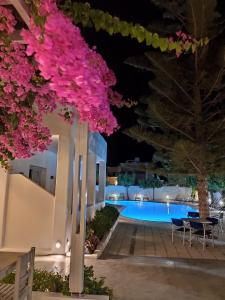a resort with a pool at night at Hippocampus Hotel in Kamari