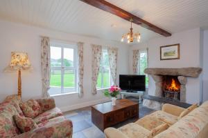 un salon avec un canapé et une cheminée dans l'établissement Beautiful mountain views & private hot tub, à Kilcoo