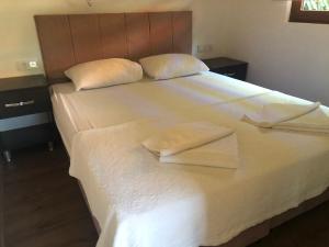 1 cama blanca grande con 2 toallas en Cirali Armira Bungalow en Cıralı