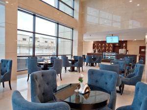 a lobby with chairs and tables and a bar at Khabti Grand Hotel in Qal'at Bishah