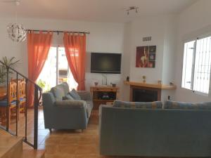 Riu Tolox في تولوكس: غرفة معيشة مع كنب وتلفزيون بشاشة مسطحة