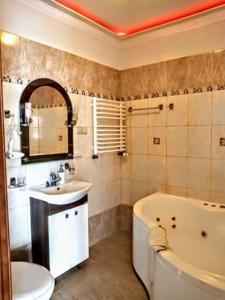 a bathroom with a tub and a sink and a toilet at Villa Europa in Mielno +74 photos
