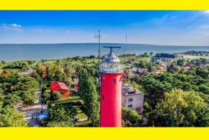 a red lighthouse in the middle of a city at Apartament Krynica Morska Rybacka Nad Zalewem in Krynica Morska