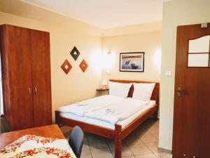 um quarto com uma cama, uma mesa e uma porta em Villa SORENTO em Mielno