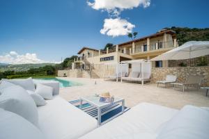 sala de estar con sofá blanco y piscina en Villa le Fontanelle, en Gasperina