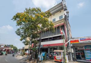 a tree in front of a building on a street at bumimakhraja syariah 4 in Bandung