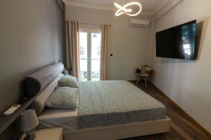 um quarto com uma cama e uma televisão de ecrã plano em Double Romantic Suite em Atenas