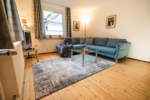 a living room with a blue couch and a table at Ferienwohnung im Ottenhai (EG) in Bad Harzburg