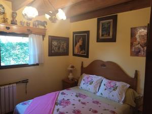 a bedroom with a bed with pink sheets and a window at Casa Rous in Molló