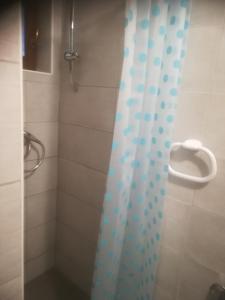 une douche avec rideau de douche bleu et blanc dans l'établissement Apartmani Huljev, à Primošten