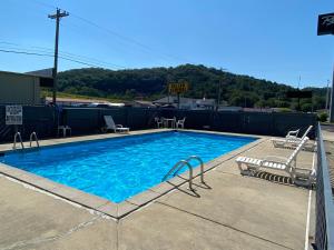a large swimming pool with two chairs at Riverfront Lodge in Burkesville