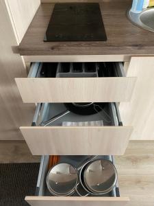 a drawer in a kitchen with some pots and pans at Kitas krantas in Juodkrantė