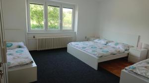 sypialnia z 2 łóżkami i oknem w obiekcie PENZION RAMRAM w mieście Nový Poddvorov