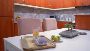 - une table de cuisine avec un plateau de fruits et une boisson dans l'établissement ThirtyFive Apartment, à Aridaía