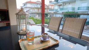 una mesa con un vaso de agua y una taza en el balcón en ThirtyFive Apartment, en Aridaía