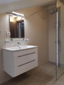 a bathroom with a white sink and a shower at Apartments Becici in Budva +137 photos