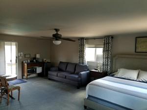 een slaapkamer met een bed, een stoel en een bank bij Ronnie's Resort in Payson +11 foto's