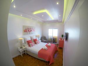 um quarto com uma cama com almofadas cor-de-rosa em Luxury Flat in Faro em Faro