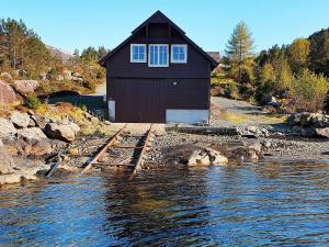 una piccola casa sulla riva di un corpo d'acqua di Holiday home Svelgen a Svelgen