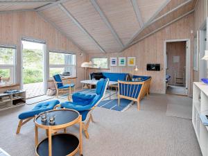 een woonkamer met blauwe stoelen en een tafel bij 8 person holiday home in Henne in Henne Strand