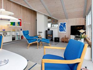 een woonkamer met blauwe stoelen en een tafel bij 8 person holiday home in Henne in Henne Strand