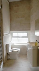 La salle de bains est pourvue de toilettes, d'un lavabo et d'une fenêtre. dans l'établissement Heart of Shoreditch, à Londres