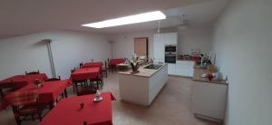 a kitchen with red tables and chairs in a room at Da Andrea e Raffaella in SantʼAnna dʼAlfaedo