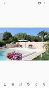 een zwembad met bloemen in een tuin bij Villa Dei Fiori in Locorotondo