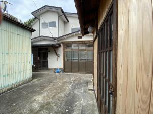 ein Garageneingang zu einem Haus mit Auffahrt in der Unterkunft mooi guesthouse 日新町 in Aizu-Wakamatsu
