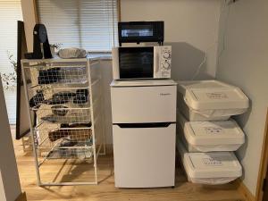 a microwave sitting on top of a refrigerator at mooi guesthouse 日新町 in Aizuwakamatsu