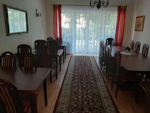 un comedor con mesas y sillas y una gran ventana en Apartamenty i Pokoje Willa Dafne en Ciechocinek