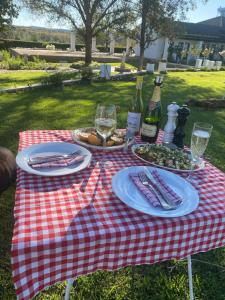 a picnic table with plates of food and wine bottles at Steenkoppies Estate semi self catering unit 2 in Magaliesburg