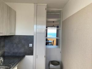 a kitchen with white cabinets and a view of the ocean at Duplex Valras face mer in Valras-Plage +9 photos