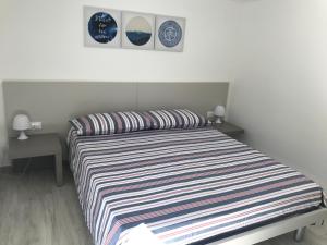 a bedroom with a striped bed with two night stands at Villa Noto-Giardino degli Allori Scopello in Balata di Baida