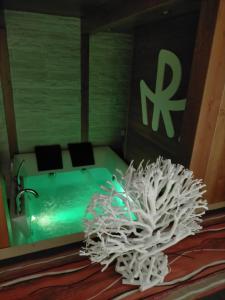 a bathroom with a green tub and a white plant at La Maison du Relax in Foggia