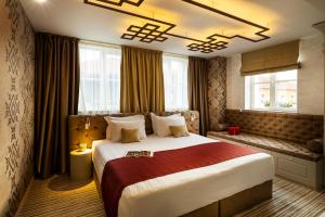 a hotel room with a large bed and windows at Art Boutique Hotel Gallery 37 Plovdiv - Superb Location in the Old Town in Plovdiv