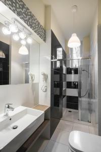 uma casa de banho com um lavatório e uma cabina de duche em vidro. em Yourplace M57 Apartments em Cracóvia