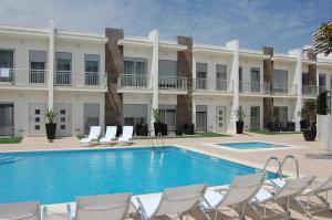 um hotel com piscina e cadeiras e um edifício em Villas Mare Residence na Nazaré