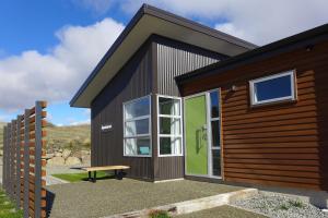 a small cabin with a bench in front of it at Cairnsmore Apartment in Lake Tekapo