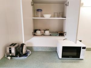 
a kitchen with a microwave and a cupboard at Ballarat Eureka Lodge Motel in Ballarat
