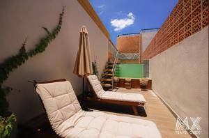 eine Terrasse mit 2 Stühlen und einem Sonnenschirm in der Unterkunft Mansión E. Borbón in León
