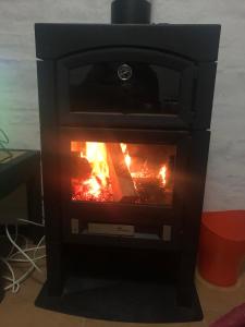 a black stove with a fire in it at Atlantida casi en la playa in Atlántida