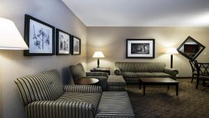 una sala de estar con 2 sofás y sillas en una habitación de hotel en Holiday Inn Springdale-Fayetteville Area, an IHG Hotel en Springdale