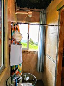 uma casa de banho com um lavatório e uma janela em Cabaña Mountain View em Heredia