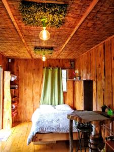 ein Schlafzimmer mit einem Bett in einem Holzzimmer in der Unterkunft Cabaña Mountain View in Heredia