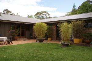 a house with a patio with potted plants on it at Bundanoon @2578 in Bundanoon