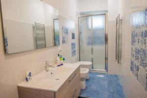 ein Badezimmer mit einem Waschbecken, einem WC und einem Spiegel in der Unterkunft A casa da putìa, l'emozione di un tramonto in Milazzo
